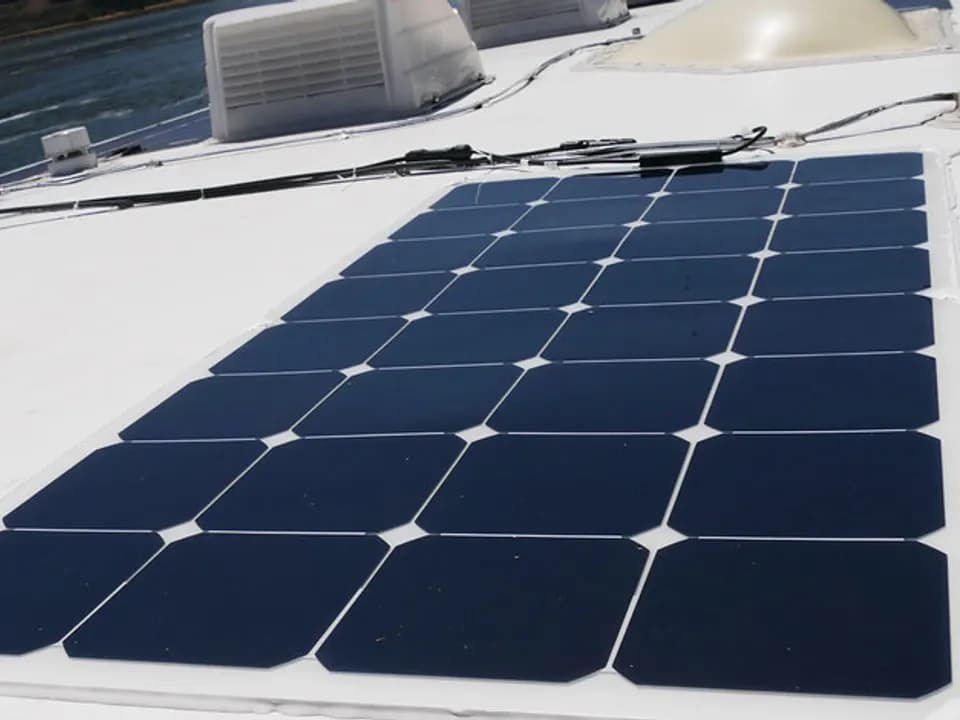 Flexible panel glued flat on the white roof of an RV