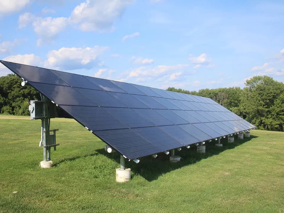 A row of large panels on a ground mount, in a field